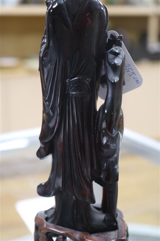 A Chinese faux amber standing figure of Xi Wangmu with a phoenix, wood stand, 23.5cm